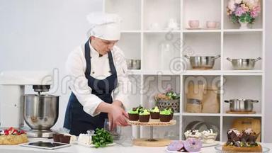 女糖果师撒巧克力薯片纸杯蛋糕装饰甜点。 4K红色相机拍摄